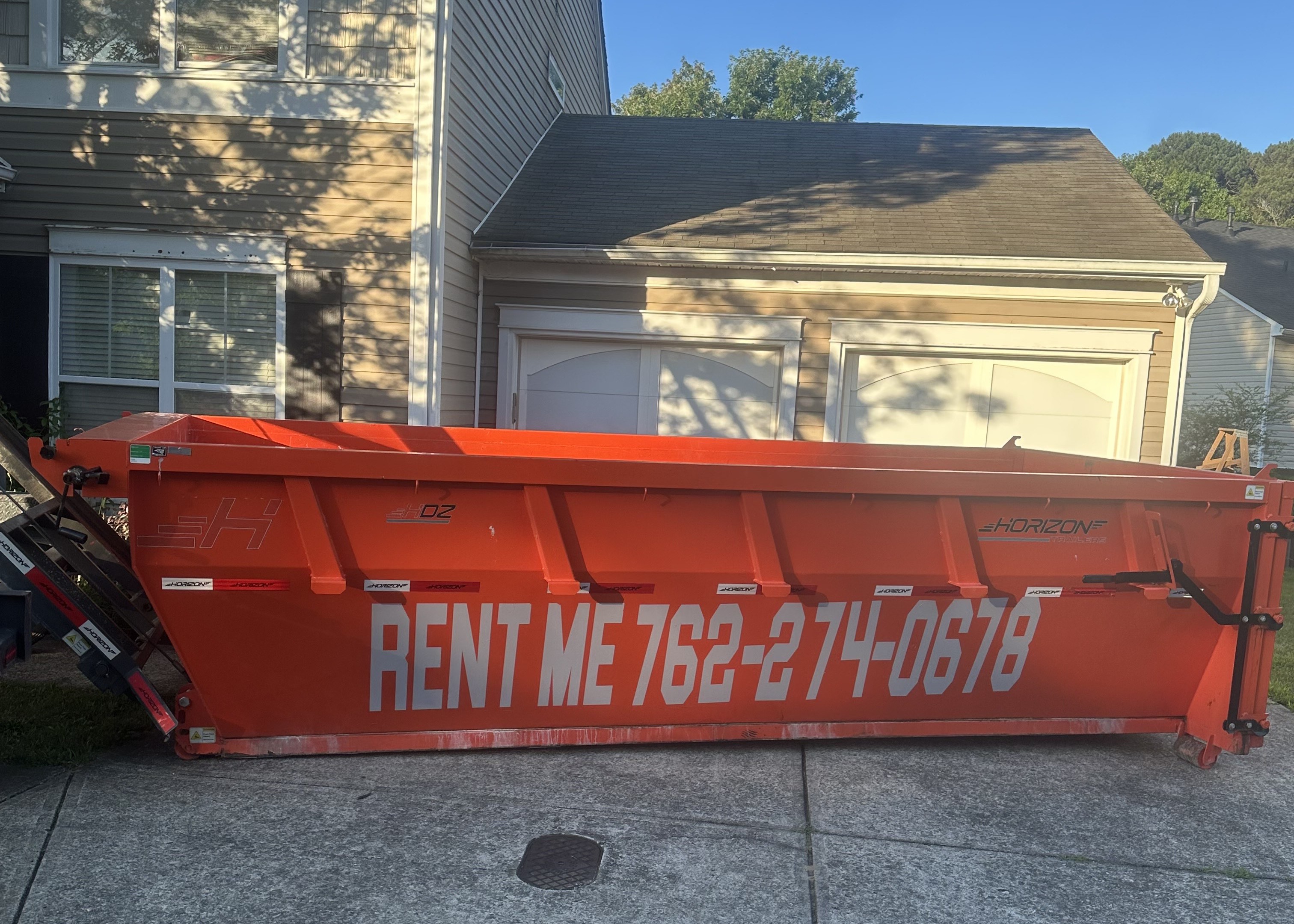 Red dumpster placed in a driveway