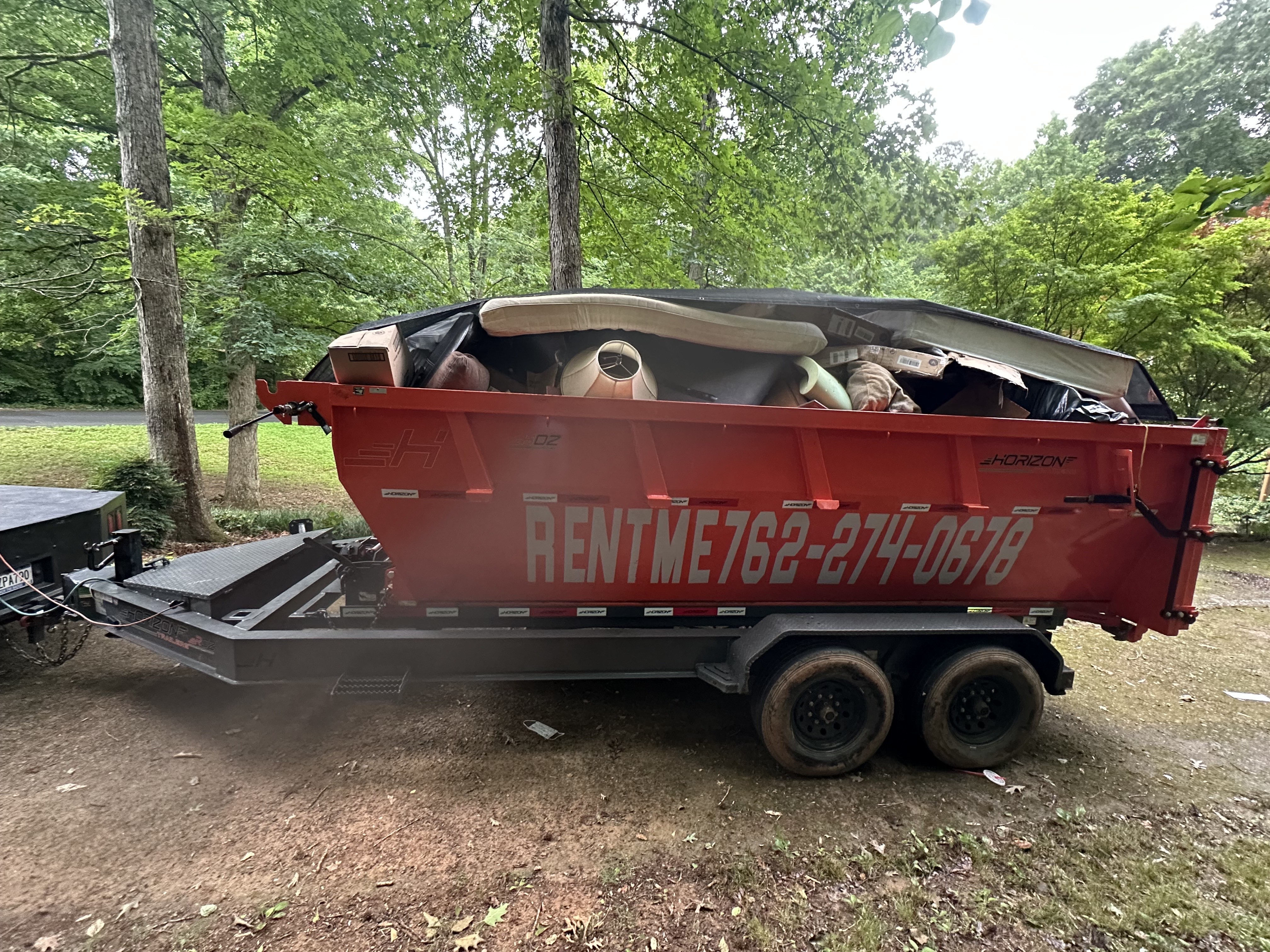 Loaded red dumpster on trailer